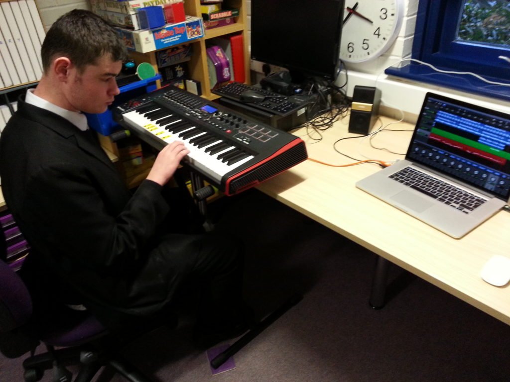 One of the group members using the keyboard, to compose and record his track, on to the laptop.