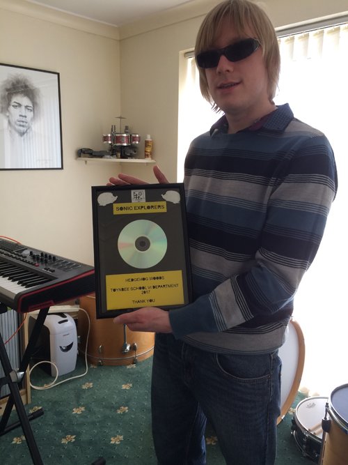 David holding a framed CD, given to the team, by the group, to say thank you.