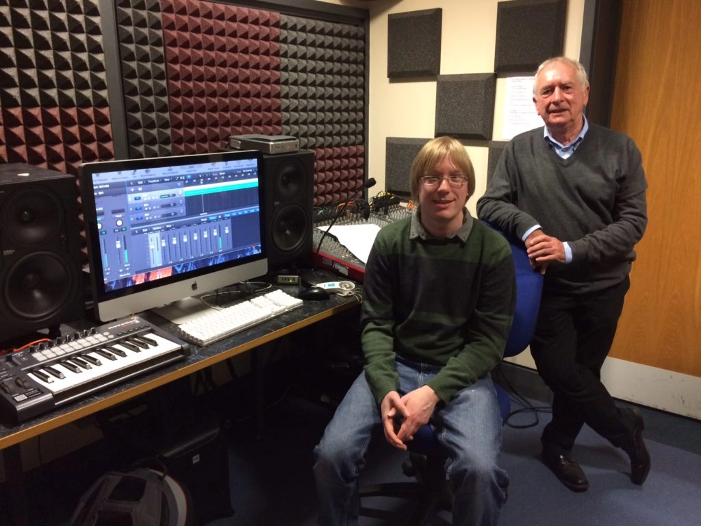 Picture of David and Richard in the recording studio, listening back to the recording, on the computer.