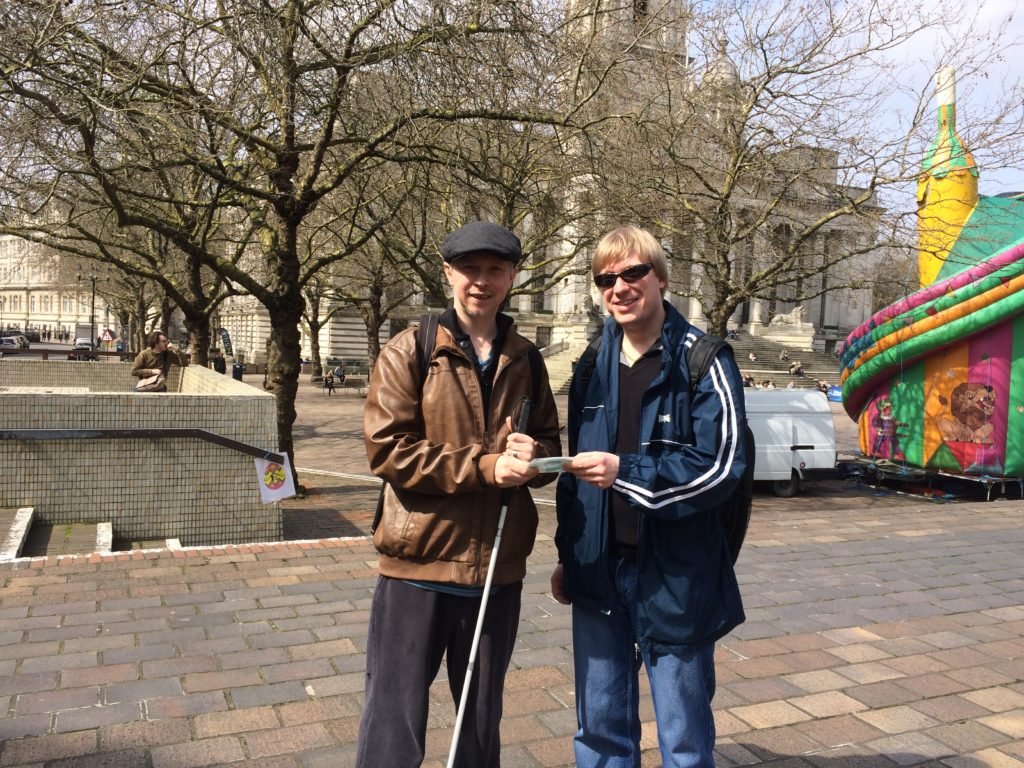A picture of David from Global Music Visions C.I.C. handing Clarke Reynolds a CD of created backing tracks for his inclusive Art Exhibition.