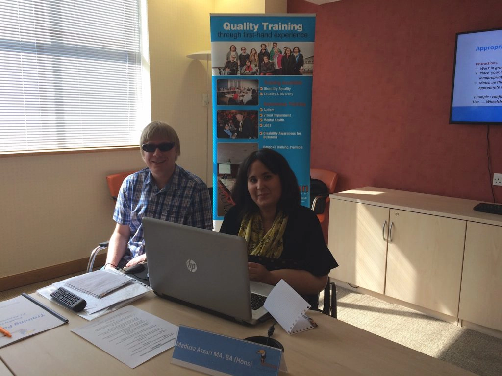 From left to right, David and Madissa are sitting at the end of the table, with the laptop open in front of them.