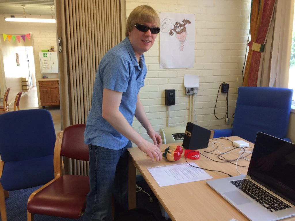 A picture of David setting up the laptop and speakers on a table, ready for the session.