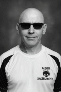 Sam is facing the camera wearing his Alien Instruments t-shirt.